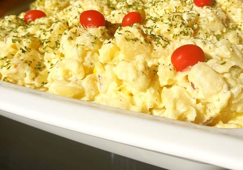 Creamy potato salad with parsley and cherry tomatoes on a white dish